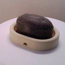 3D-printed oval soap dish with drain rack, white and wood-look.