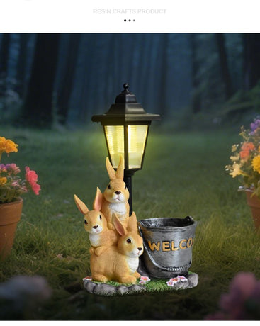 Solar Simulation Rabbit Ornament, charges by day and lights up automatically at night, three rabbits cluster around a street lamp with 
