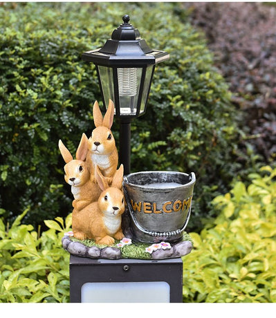 Solar Simulation Rabbit Ornament, charges by day and lights up automatically at night, three rabbits cluster around a street lamp with 